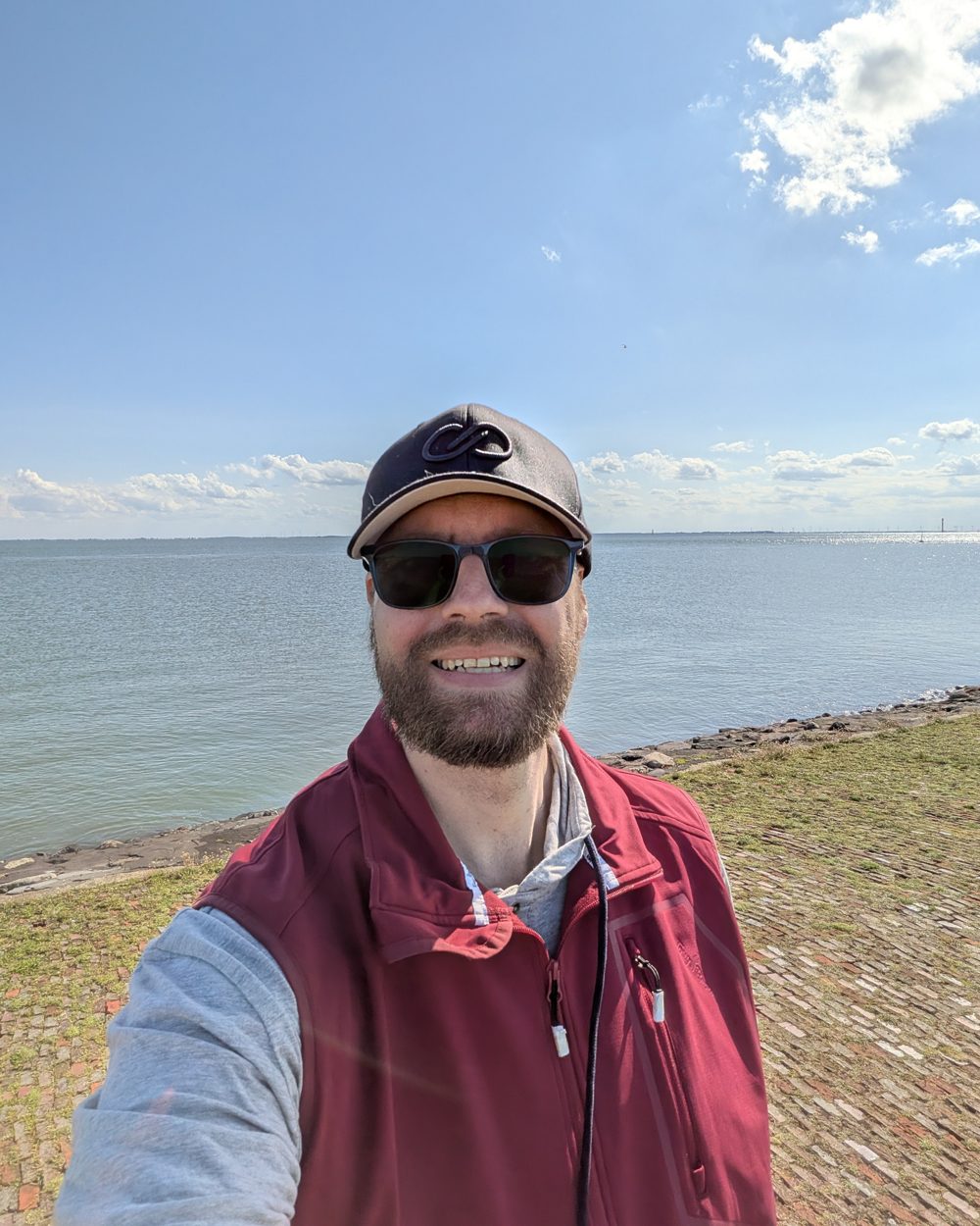Marcus Aßhauer mit Cap und Sonnenbrille am Meer